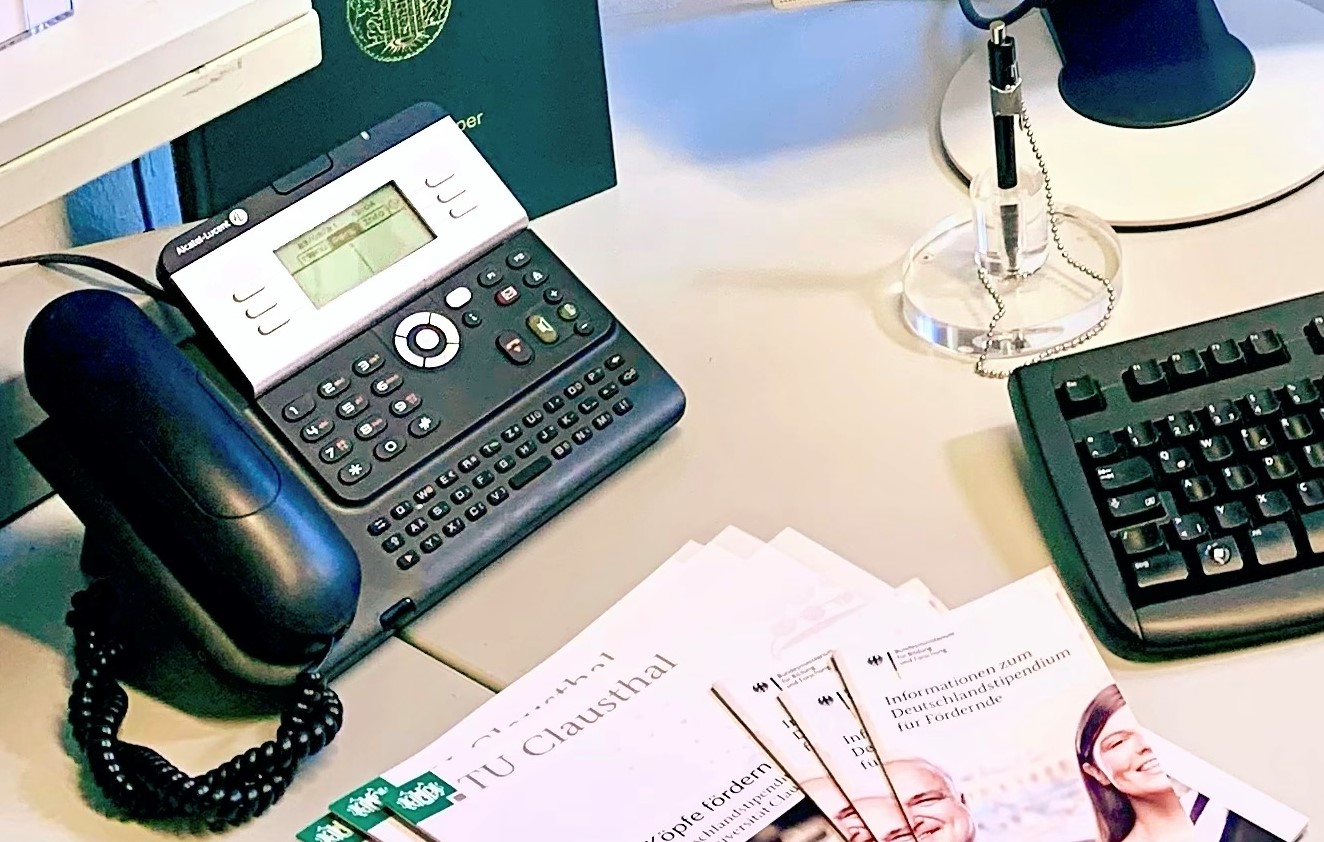 Telefon auf einem Tisch neben einigen Dokumenten und einer Tastatur