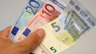 Hand mit Euro-Geldscheinen von 5, 10 und 20 Euro