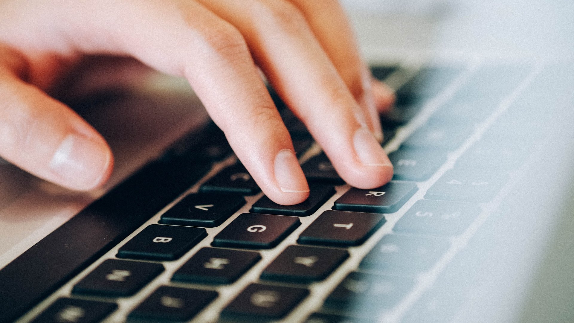 Hand auf der Tastatur, die etwas tippt